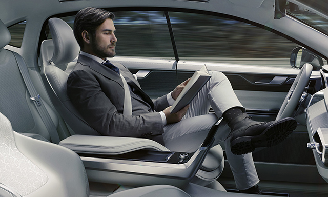 A man reading in his driverless car